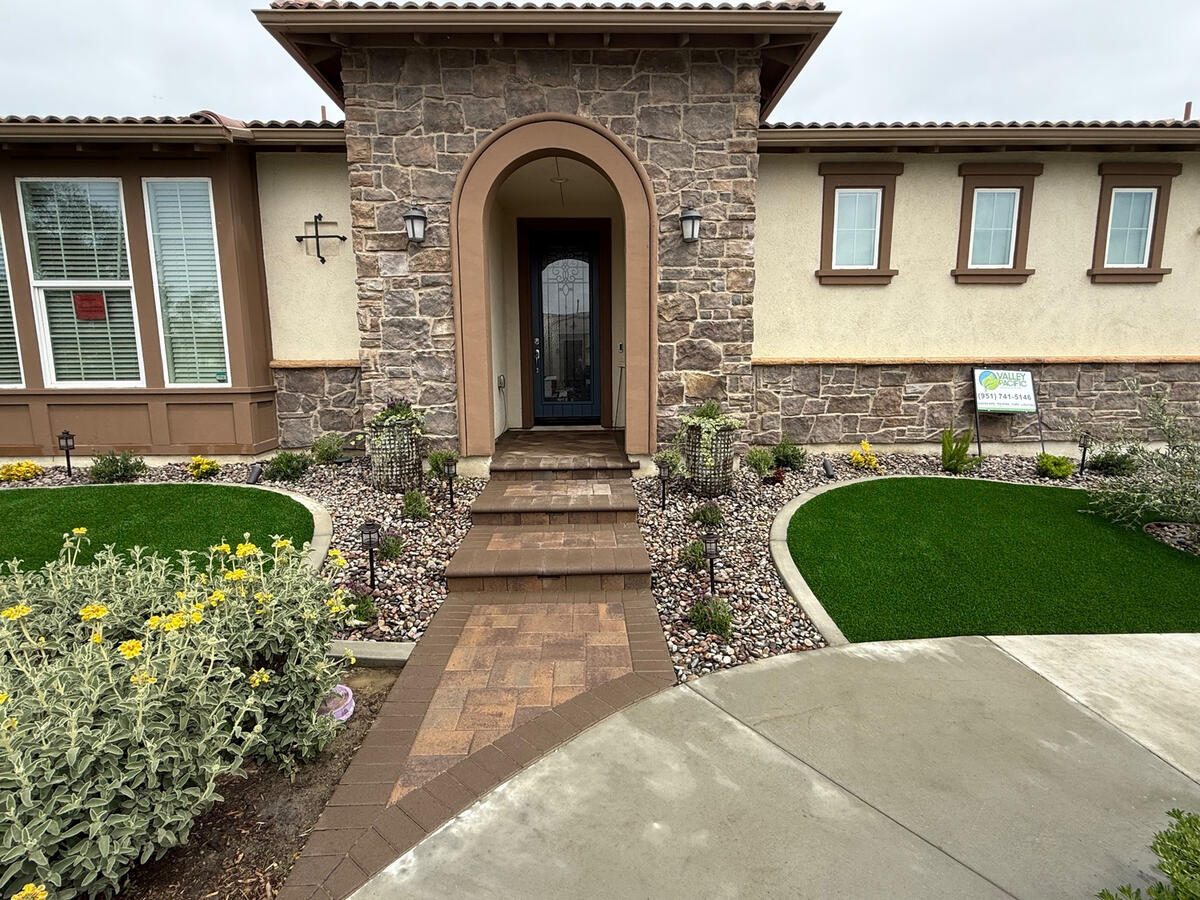 Finished backyard featuring professional artificial turf and paver installation in Riverside, CA. Backyard after artificial turf and paver installation in Riverside, California.
